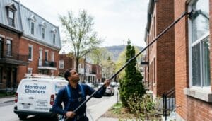 Professional window cleaning technician using water-fed pole system in Montreal